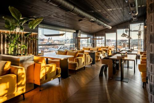 利沃夫Loft7的餐厅设有黄色的椅子和桌子以及窗户。