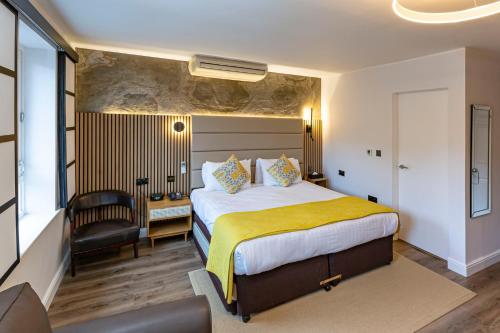 哈罗盖特斯塔德利酒店的配有一张床和一把椅子的酒店客房