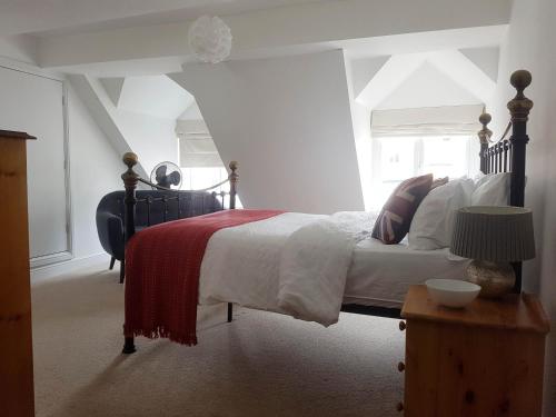 沃里克Warwick Market Place Apartment的一间卧室配有一张带红白毯子的床