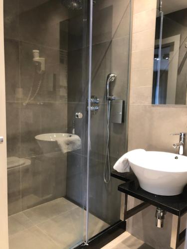列日乐凯恩银D酒店的一间带水槽和玻璃淋浴的浴室