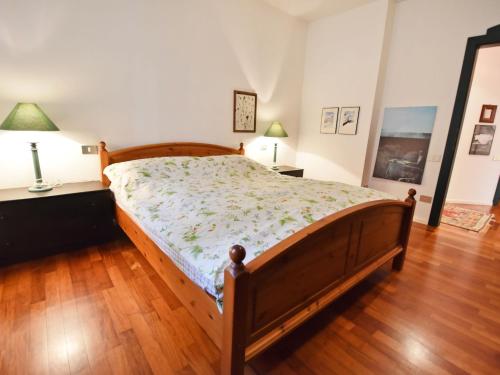 梅拉诺Apartment Villa Esperia by Interhome的卧室内的一张床位,铺有木地板