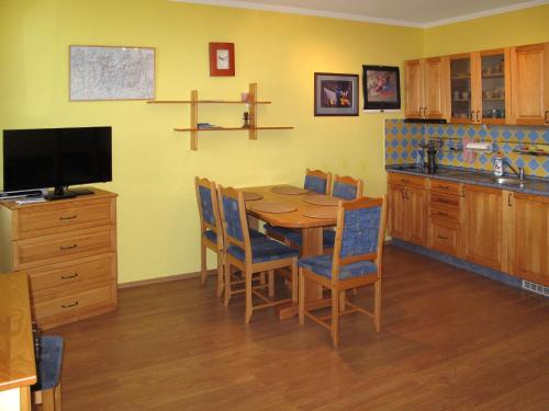 维特科维采Apartment Horní Mísečky - HMS110 by Interhome的厨房配有木桌、椅子和电视