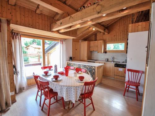 南达Apartment Bisse-Vieux A-4 by Interhome的厨房配有红色椅子和白色桌布。