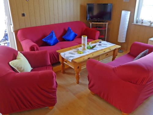 多纳莫塞尔胡斯吉拉酒店的客厅配有红色沙发和咖啡桌