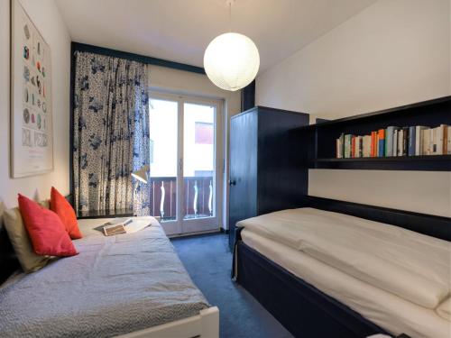 圣莫里茨切萨浪漫公寓的一间卧室设有一张床和一个带书架的窗户