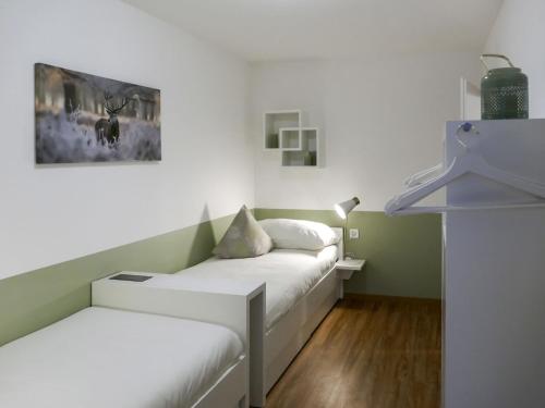 圣莫里茨欧瓦考茨纳12/14公寓的一间设有两张床的客房,墙上挂着一幅画