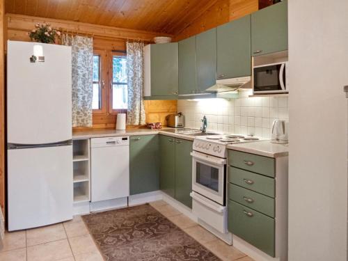 拉赫登佩拉Holiday Home Kurre by Interhome的厨房配有绿色橱柜和白色冰箱
