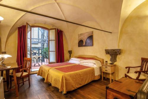 佛罗伦萨阿尔巴宫殿酒店的卧室配有一张床和一张桌子及椅子