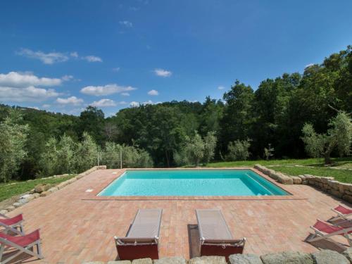 罗卡斯特拉达Holiday Home Casa la Selvolina by Interhome的一个带2把躺椅的游泳池和一个游泳池
