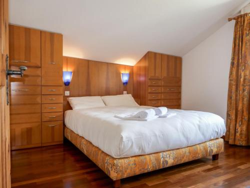 锡尔斯玛丽亚Apartment Chesa Polaschin E - E21 - Sils by Interhome的一间卧室配有一张带木制橱柜的大床