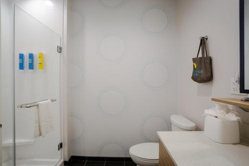 普弗拉热维尔Tru by Hilton Pflugerville, TX的带淋浴、卫生间和盥洗盆的浴室