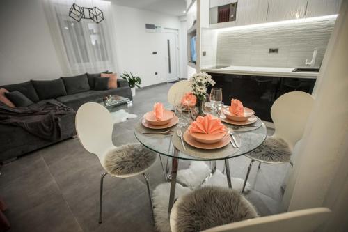 BogatićKoVeL apartmani - Termalna Rivijera的客厅配有桌椅和沙发