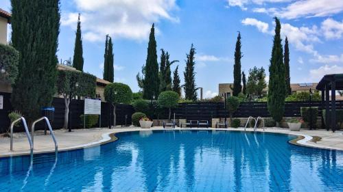 库克里亚Aphrodite Hills Adonis Apartment的一座树木环绕的大型游泳池