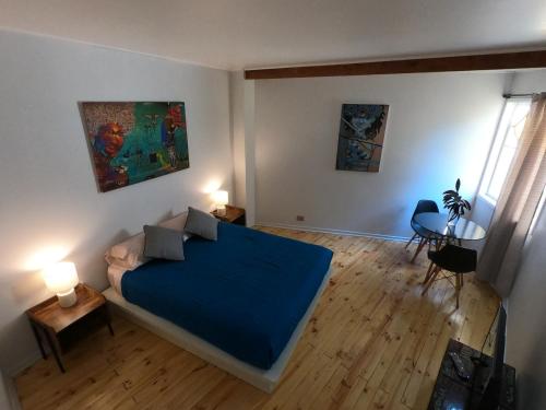 瓦尔帕莱索爱斯卡拉巴乔旅舍的一间卧室配有一张带蓝色毯子的床