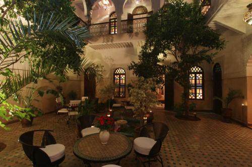 马拉喀什里亚德马思巴摩洛哥传统庭院住宅的大堂设有桌椅和植物