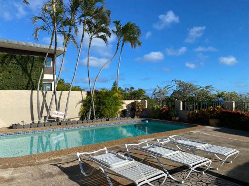檀香山Paradise at Ehupua的一个带躺椅的游泳池,棕榈树