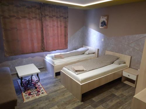 伊利扎Apartments "Our Place" Sarajevo的一间设有两张床和一张桌子的房间