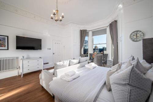 布罗迪菲利Casa Fresa - Orchar Suites的一间白色卧室,配有床和电视