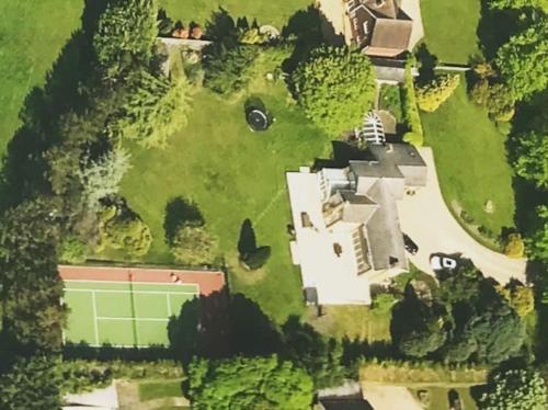 阿斯顿若望特Stunning Oxfordshire 5 Bedroom House in 2 acres的享有带网球场的房屋的空中景致