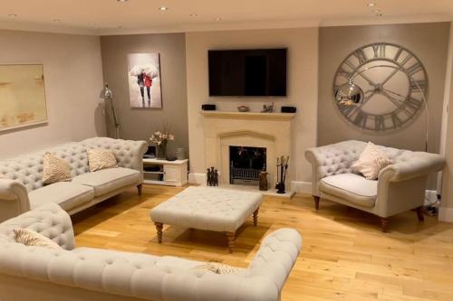 阿斯顿若望特Stunning Oxfordshire 5 Bedroom House in 2 acres的客厅配有白色沙发和壁炉
