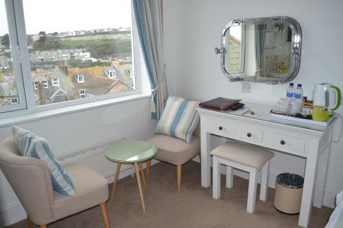 圣艾夫斯Tregony Guest House的客房设有书桌、镜子和窗户。