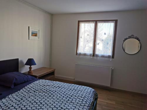 马西MASSY VILMORIN Appartement indépendant 3 pieces的一间卧室设有一张床、一个窗口和一面镜子