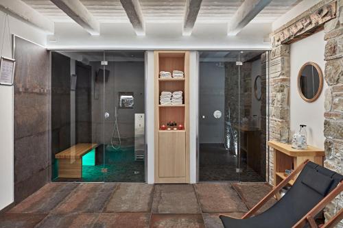 阿奎莱亚Zadris 1922 Apartments & Spa的带淋浴的浴室和玻璃门