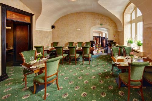 利沃夫阿特拉斯豪华酒店的一间在房间内配有桌椅的餐厅