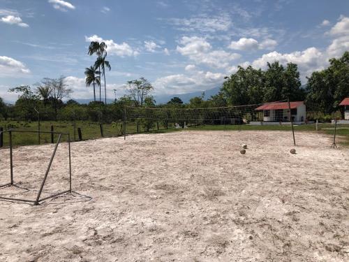 比亚维森西奥Cabañas Campestres en Villavicencio的沙地里有两个球的空排球场