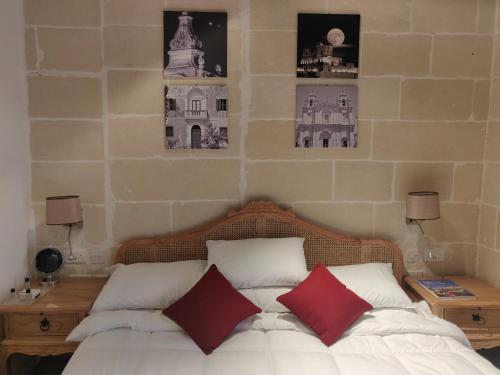 HamrunCentral 214 Boutique Hotel的一间卧室配有一张带两个红色枕头的床