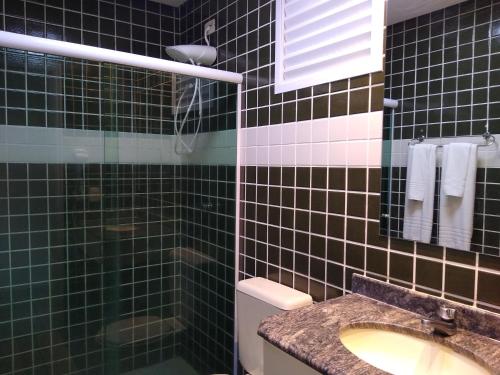 伯迪亚哥RIVIERA SERVICE- Suíte Casal -113的黑色瓷砖浴室设有水槽和淋浴