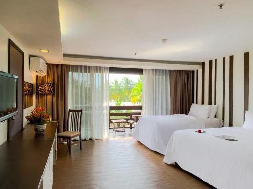 山都望达迈海滩度假村的酒店客房设有两张床和电视。