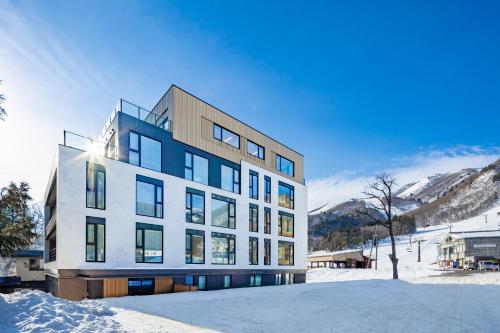 白马村ROKA by Hakuba Hotel Group的一座山地雪地建筑