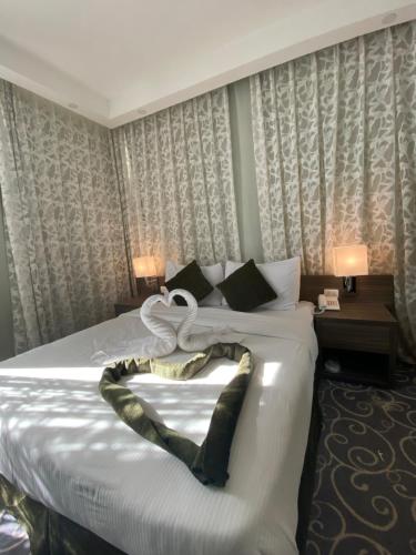 安曼阿蒙德酒店公寓的酒店客房,配有一张带白色棉被的床
