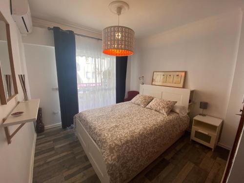 桑卢卡尔-德巴拉梅达Casa Ana的一间卧室配有一张床和一个吊灯