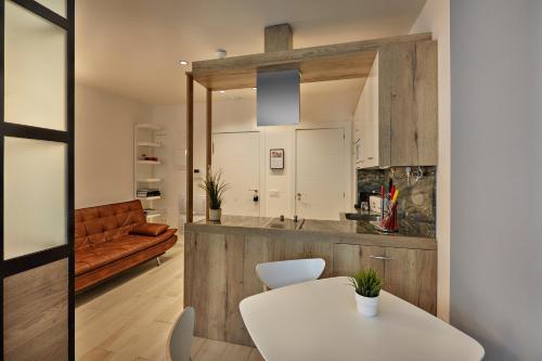 洛格罗尼奥Apartamentos Abastos的厨房配有白色的桌子和沙发