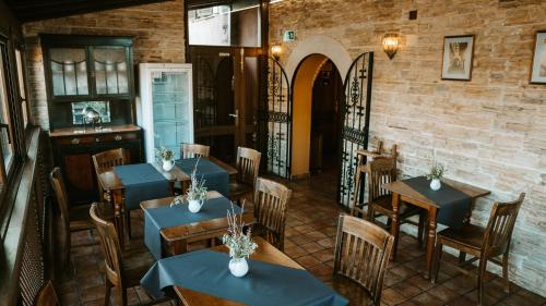 昆卡Hospedería Ballesteros的一间带桌椅的餐厅以及砖墙