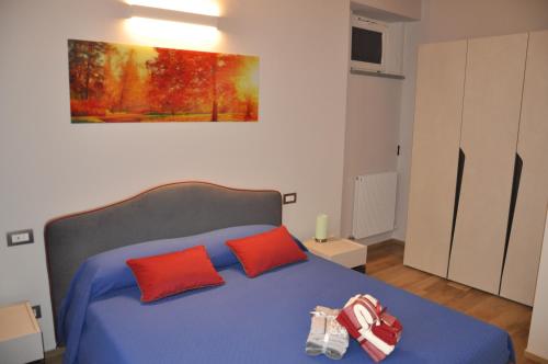 科斯蒂廖莱达斯蒂Sotto la torre的一间卧室配有蓝色的床和两个红色枕头
