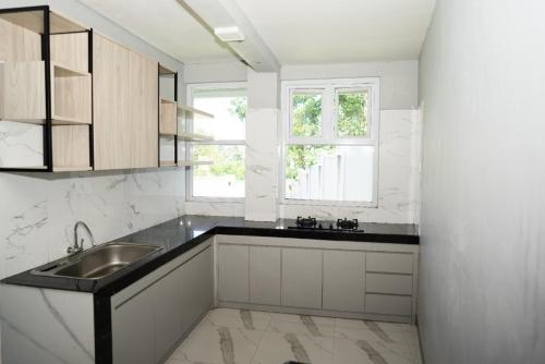 BedoyoVilla Languket I的白色的厨房设有水槽和窗户