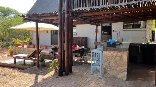 侯斯普瑞特Ujabule Lodge的一个带桌子和遮阳伞的庭院