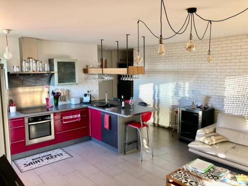 圣雷米普罗旺斯Terrasse sur les Alpilles的客厅里设有红色橱柜和沙发的厨房