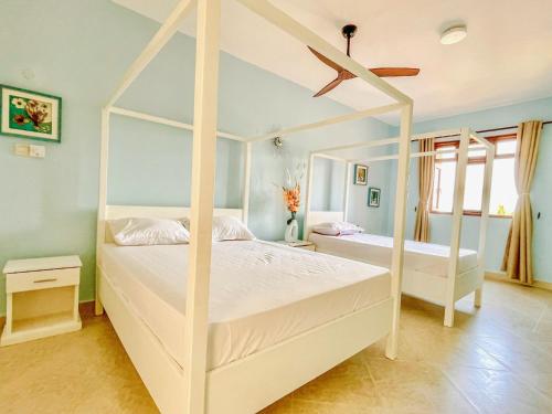 杉祖La Mera Ocean-View, 2 Bedroom - Apartment with Pool and NEW renovated Art Style Rooms的卧室配有2张白色的床和吊扇