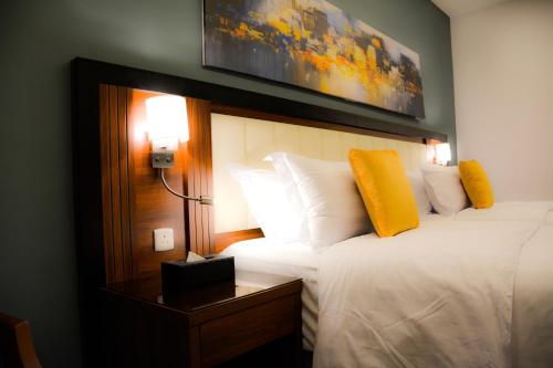 吉达Park Town的酒店客房设有一张床,墙上挂着一张照片
