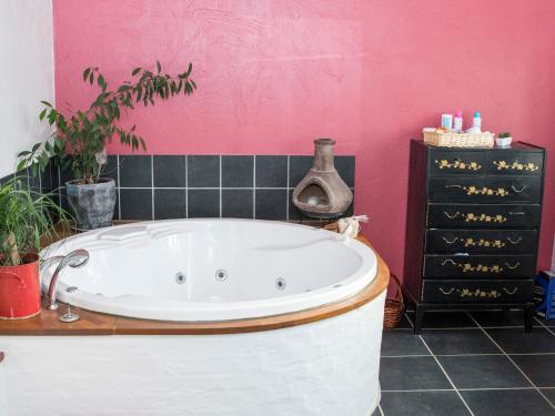 SnedstedKnakkergård的带浴缸的浴室和粉红色的墙壁