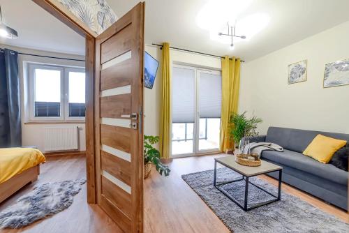 格沃古夫Apartament na Zlotej Podkowie的客厅配有沙发和桌子