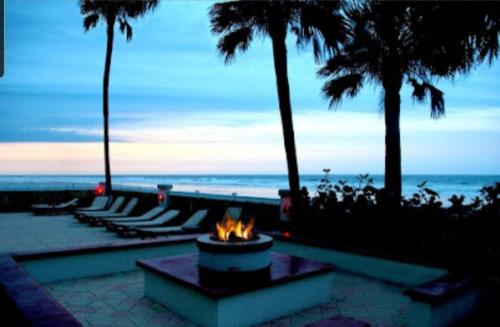代托纳海滩Stay ON the beach! Beautiful building and location!的棕榈树和海洋海滩上的火坑