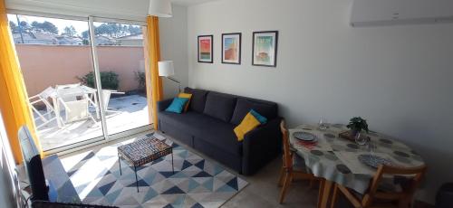 欧登日La Petite Maison du Bassin d'Arcachon - 40 m2, climatisée, indépendante et au calme的客厅配有沙发和桌子