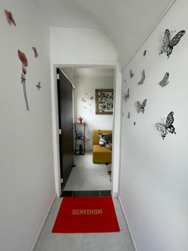 圣希尔Apartaestudio San Gil - Hostal Green的墙上有蝴蝶的走廊和红地毯