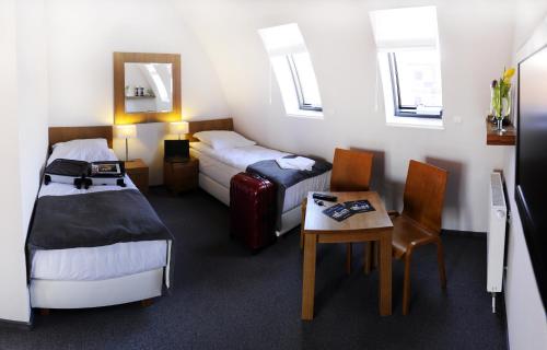 比得哥什比得哥什码头住宿加早餐旅馆的酒店客房带两张床和一张桌子以及椅子。