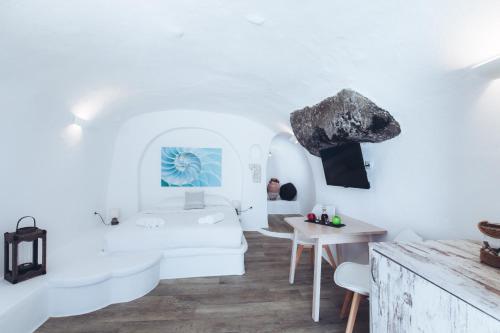 伊亚双子座洞穴度假屋的白色的客房配有白色的沙发和桌子
